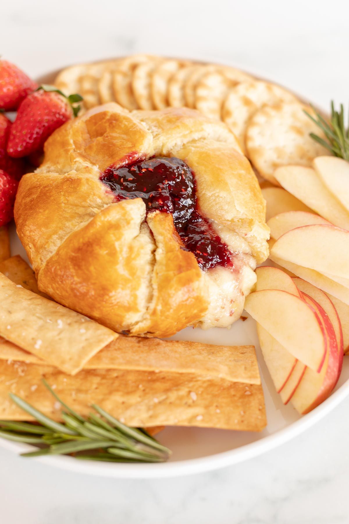 baked brie in puff pastry surrounded by fruit and crackers