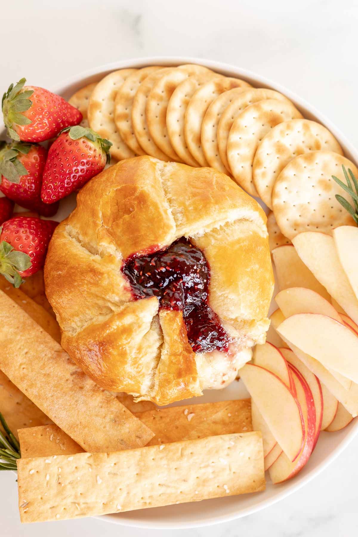 baked brie in puff pastry surrounded by fruit and crackers