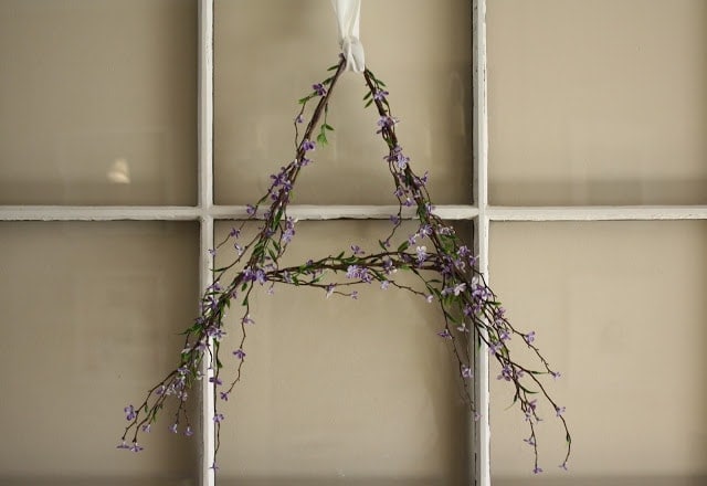 Purple flowers in the shape of an 'A' hanging on a door. 