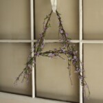 floral monogram wreath in shape of letter A hanging from window