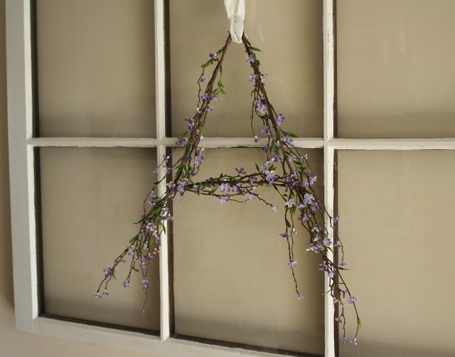 Purple flowers in the shape of an 'A' hanging on a door. 