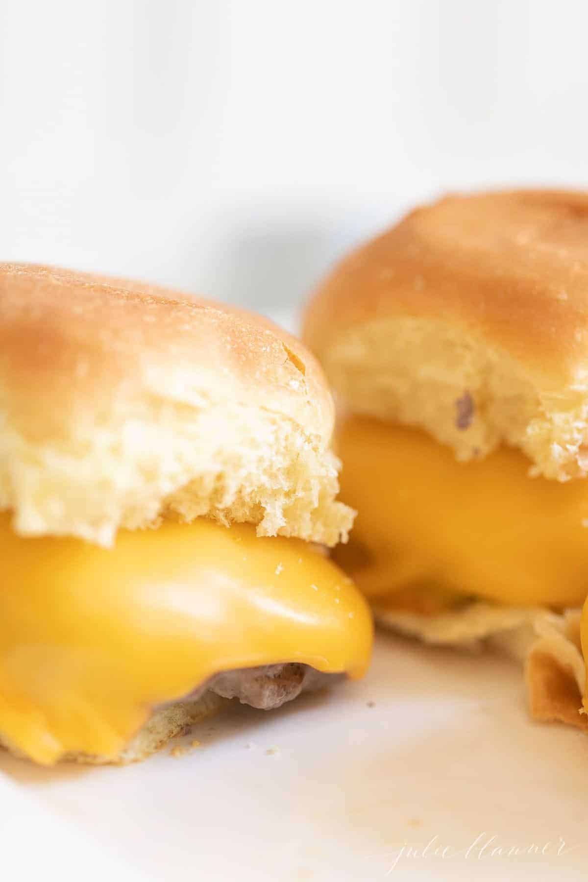 Pair of mini sliders with melted American cheese, close-up. #sliders