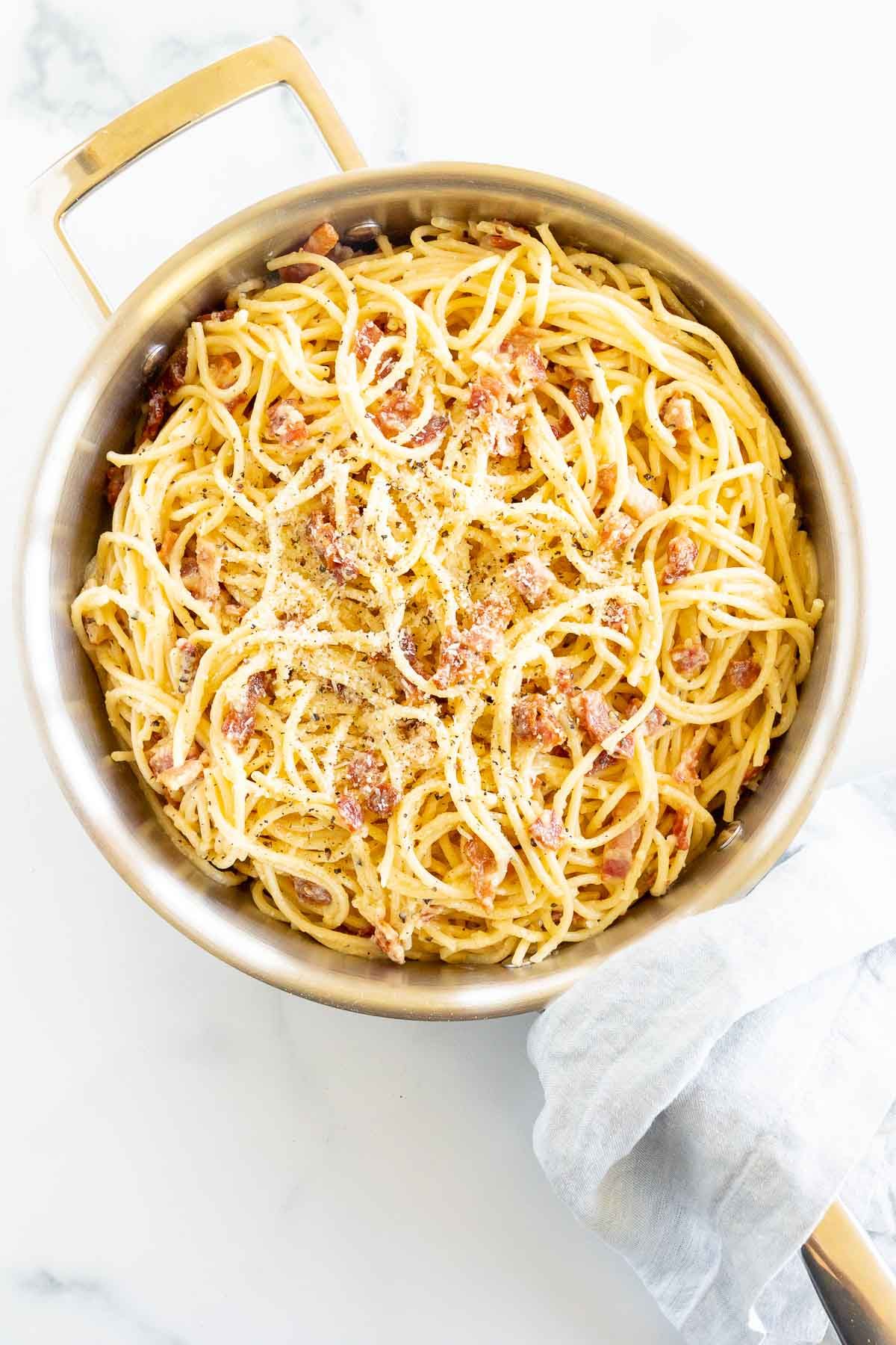 A large silver pot filled with spaghetti carbonara.