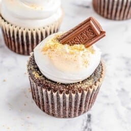 S'mores cupcakes on a marble surface.