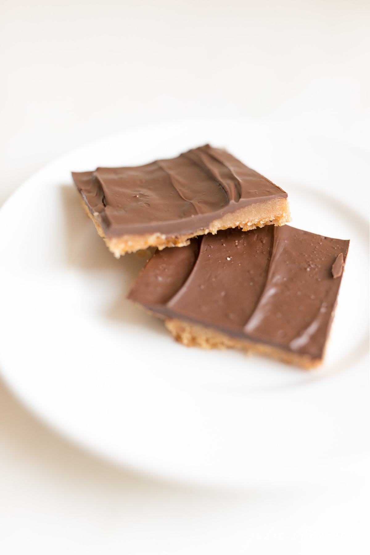 Two pieces of saltine cracker toffee on a white plate