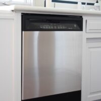 black dishwasher covered with stainless steel contact paper panel