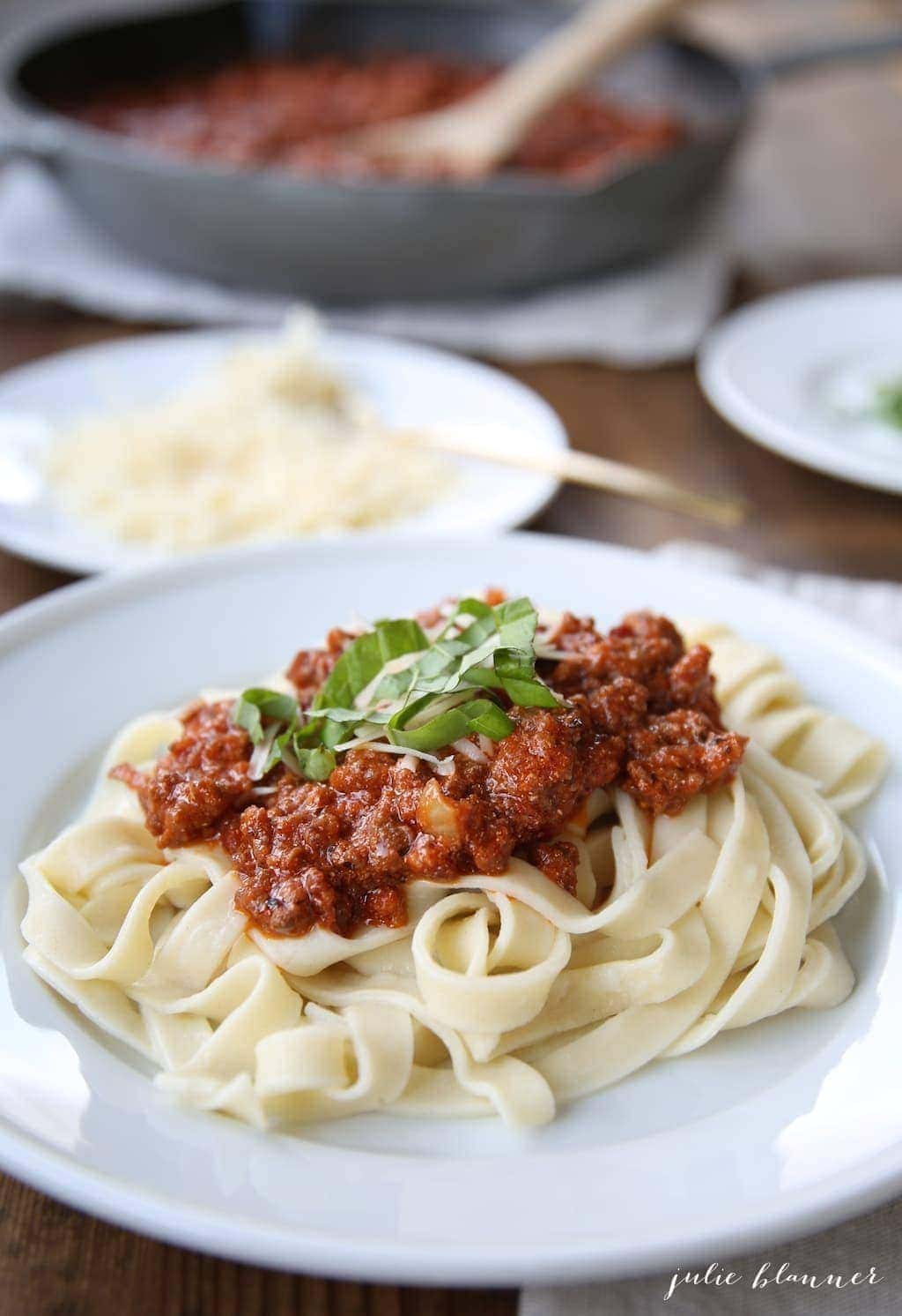 Close up of fresh basil garnish on top of the bolognese sauce