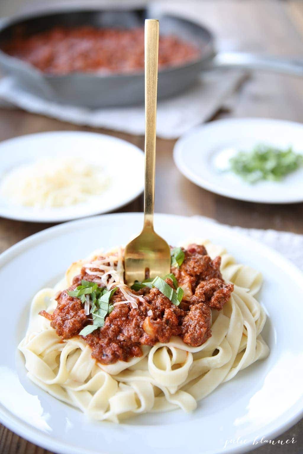A gold fork in pasta bolognese