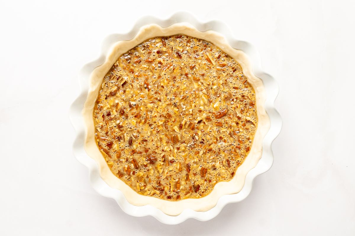 A caramel pecan pie on a white background.