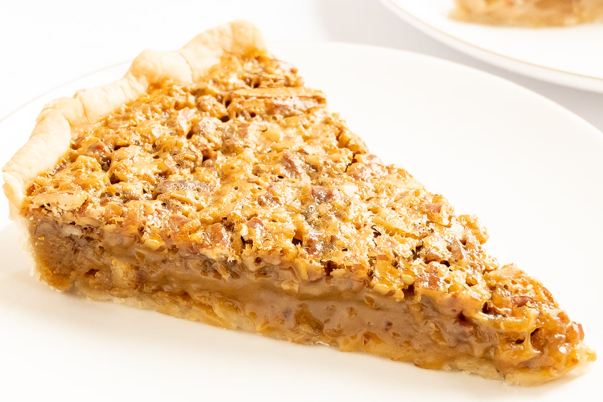 A delectable slice of caramel pecan pie on a plate.