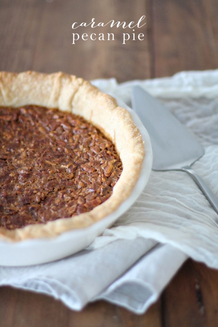 The best Caramel Pecan Pie recipe is quick and easy with the help of store-bought caramels. A rich, gooey, seasonal pie with an unbelievable texture. best caramel pecan pie in white pie dish with white towel and pie serving utensil with text overlay