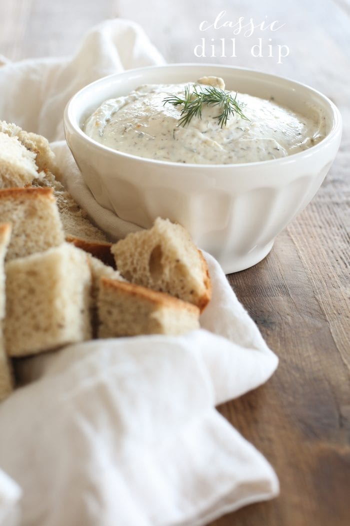 Classic, flavorful Dill Dip that's always a crowd-pleaser for holidays, game days and summer gatherings. This easy dill dip recipe can be made in 5 minutes! Dill dip in a white bowl with bread cubes