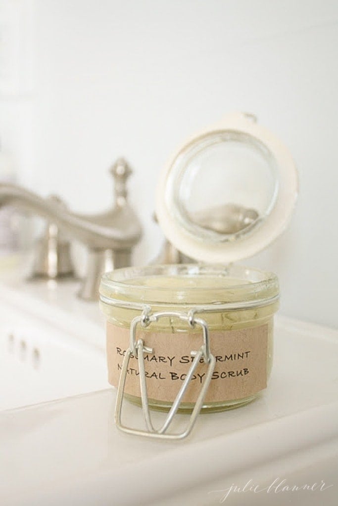 jar of sugar body scrub open on a sink