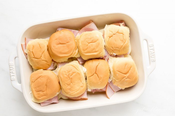 Ham and Cheese Sliders in a white dish, before being cooked or seasoned.