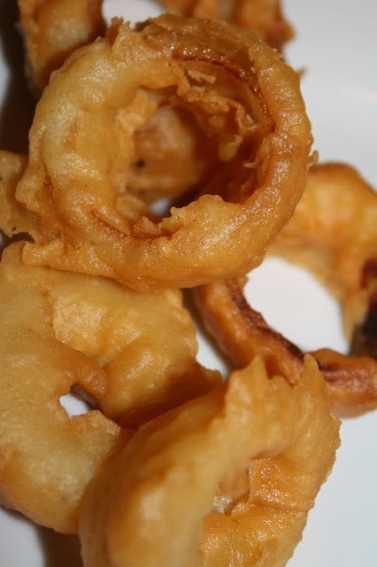 fried homemade onion rings on a white plate