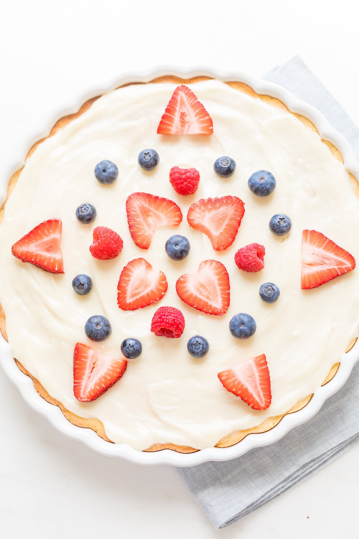 A close up of a fruit pizza with cream cheese fruit pizza icing on top.