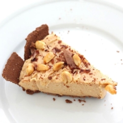 A slice of no bake peanut butter cheesecake on a white plate