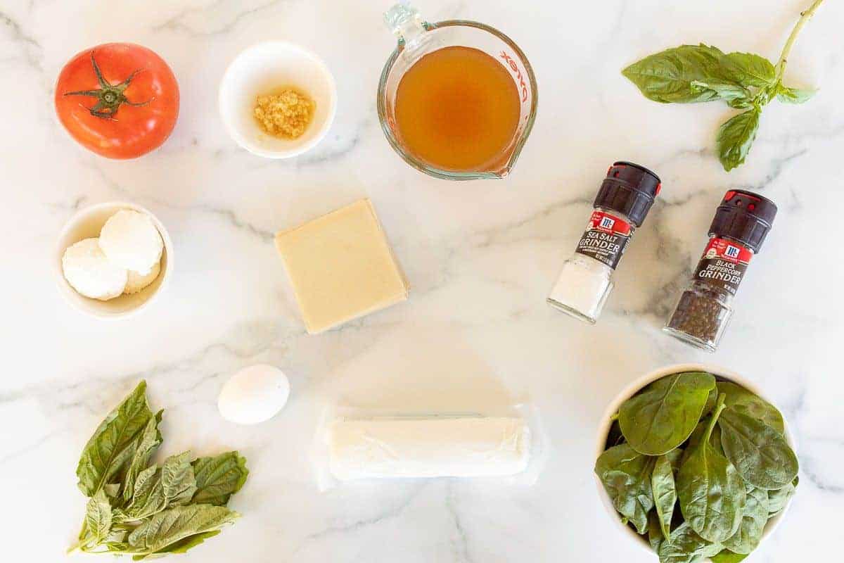 A marble surface with ingredients for a goat cheese ravioli recipe laid out.