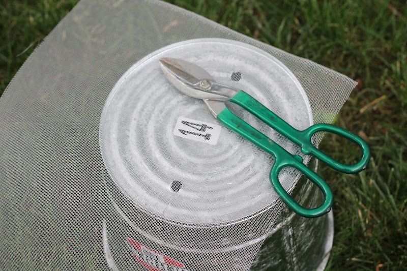 wire scissors and screen sitting on top of bucket