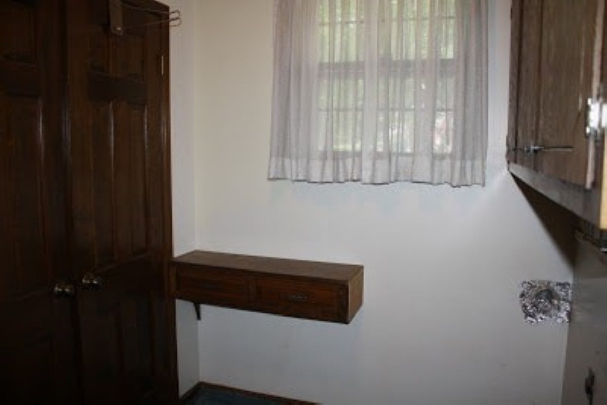 A before shot of a mudroom laundry room makeover with dark wood trim on the doors.