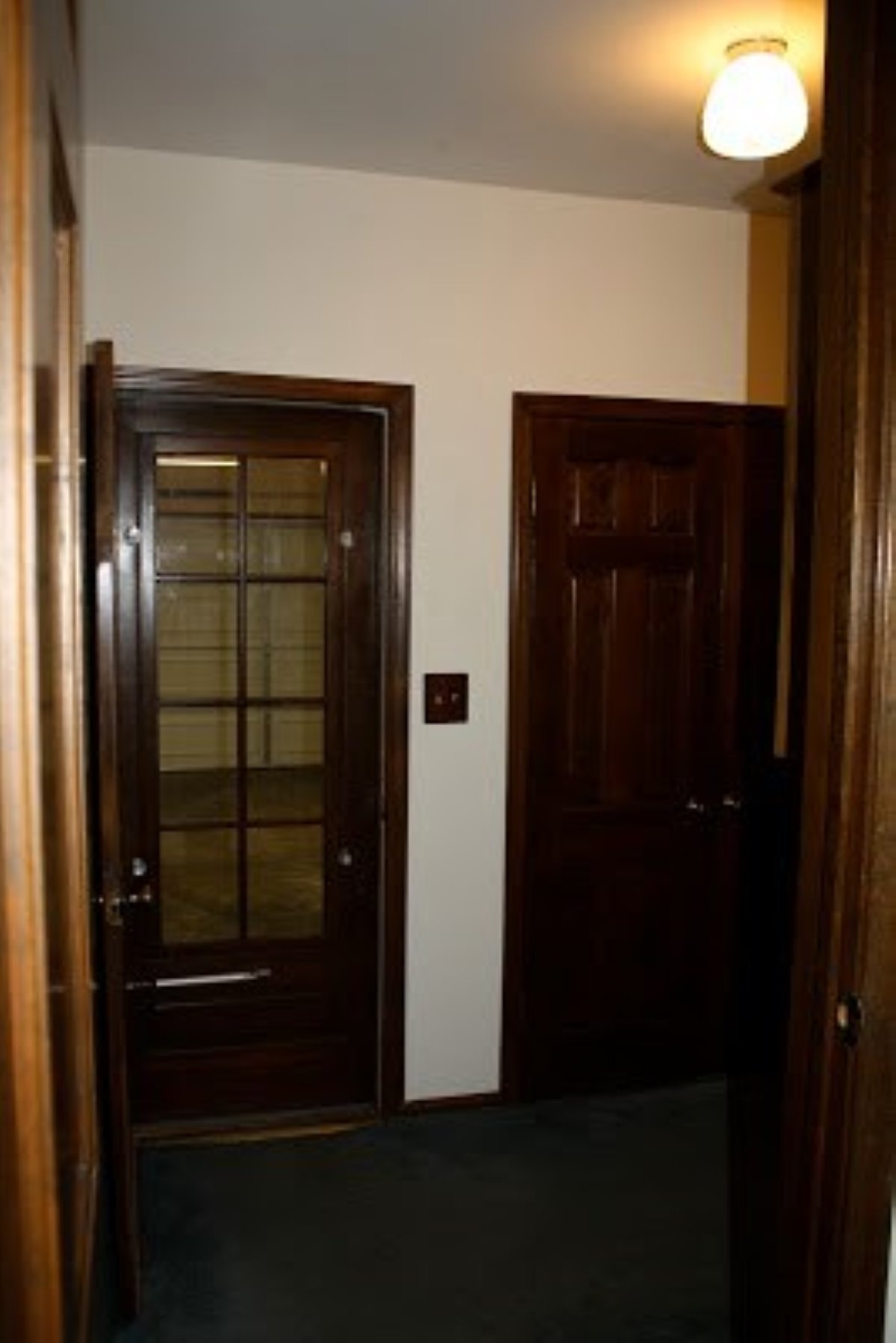 A before shot of a mudroom laundry room makeover with dark wood trim on the doors.