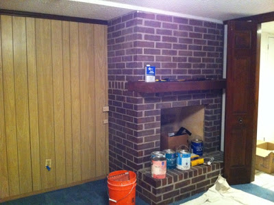 A wooden wall with a brick fireplace