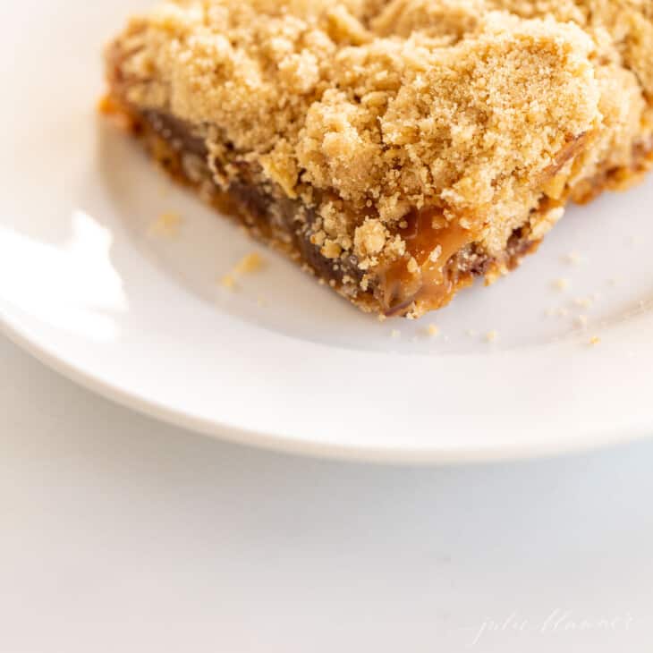 oatmeal cookie bar on white place with caramel oozing out