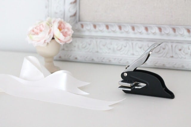 A ribbon and stapler on aa white surface.