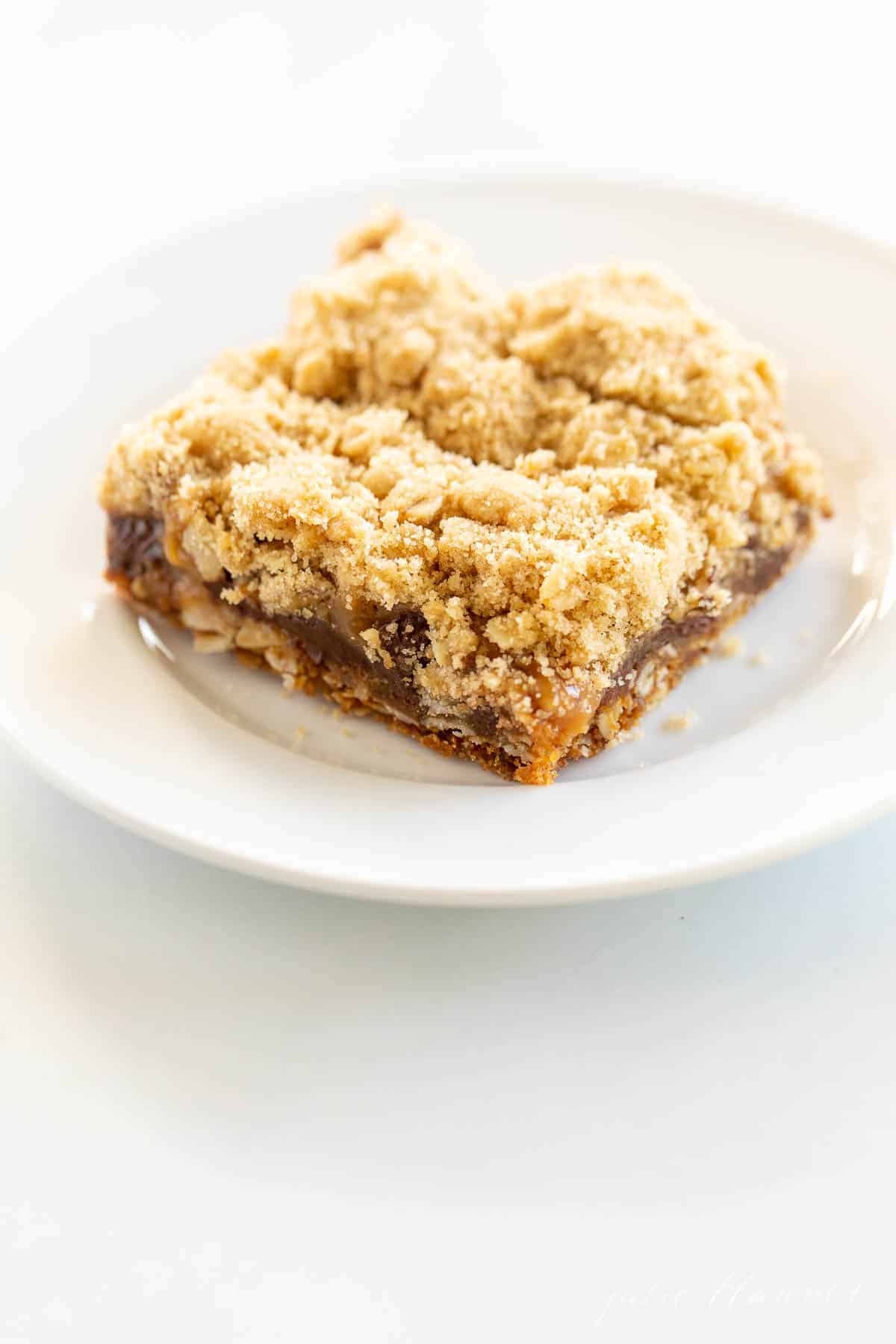 caramel oatmeal chocolate chip cookie bar on white plate