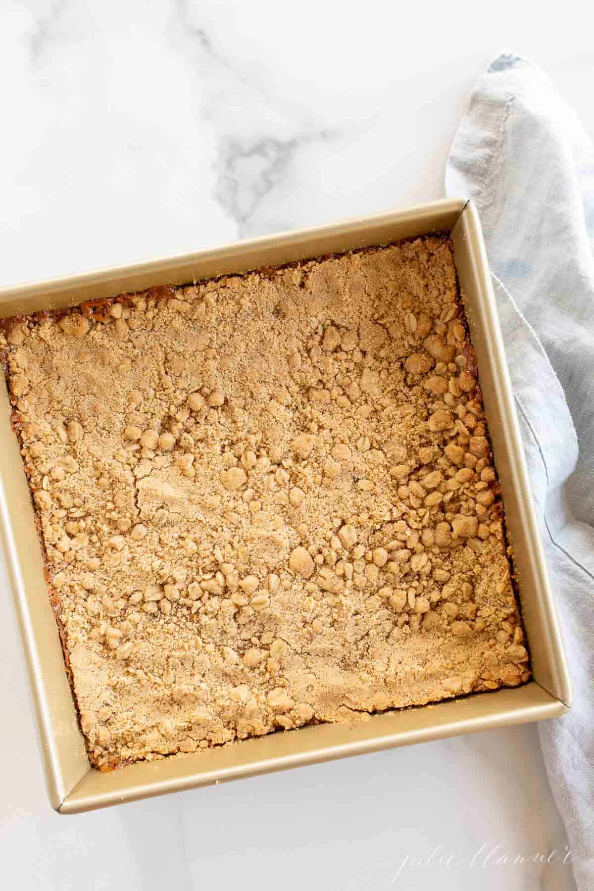 cookie bars in baking dish by blue napkin