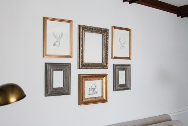 DIY gold gilded frames in a gallery wall over a sofa.