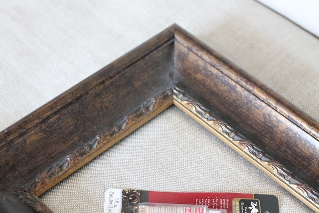 A diy tutorial of a gilded frame set out on a table.