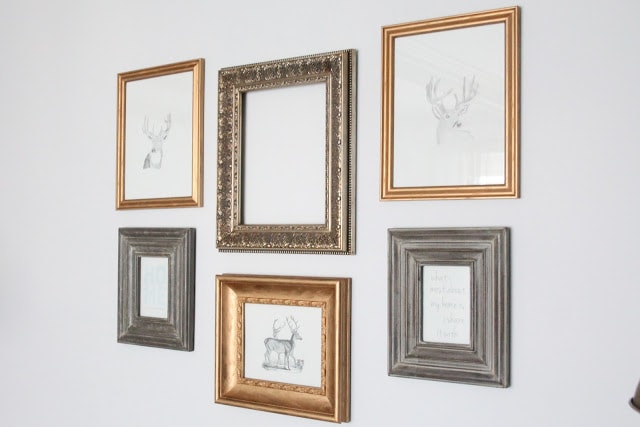 DIY gold gilded frames in a gallery wall over a sofa.