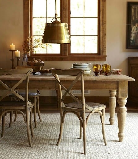 wood table and chairs with brass pendant overhead