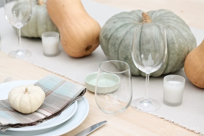 Various pumpkins and gourds on a set Thanksgiving table. 