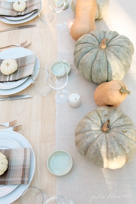 Various pumpkins and gourds on a set Thanksgiving table. 