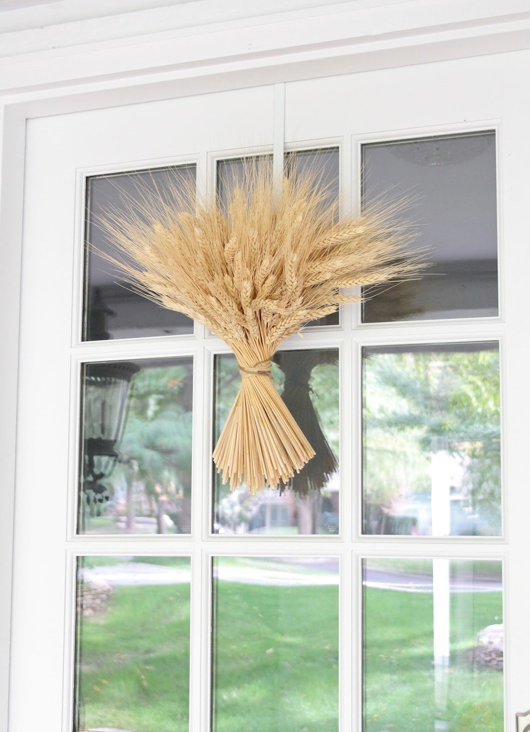 A wheat sheaf on a white front door with glass panes
