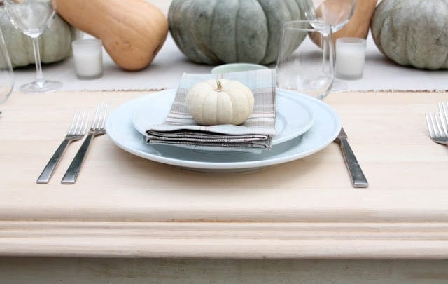 fall table setting with miniature pumpkin on napkin