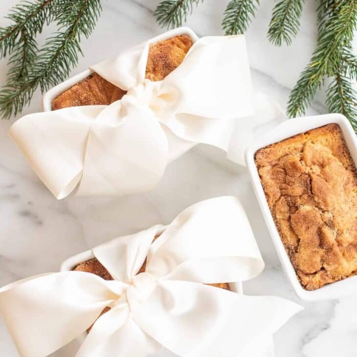 3 cinnamon bread loaves 2 gift wrapped in a bow by christmas greenery