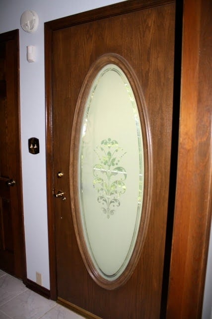 A wooden door with a big frosted glass window inside.