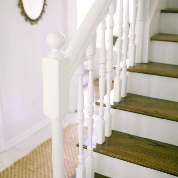 White stairs with wooden tops and white hand railings.