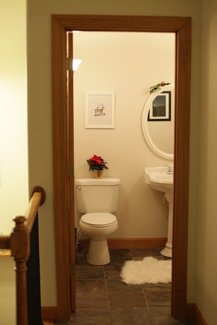 A bathroom with white appliances and festive poinsettias.
