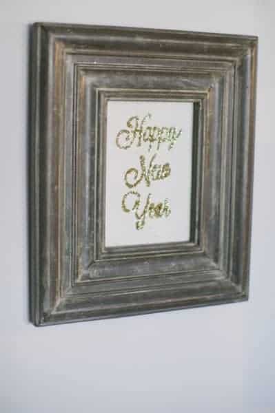 Glittered artwork in a vintage frame for a New year's Eve party idea.