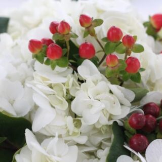 Light and dark red berry accents in white flowers.