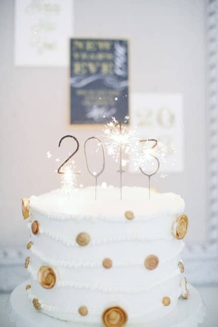 A white and gold polka dot new year's eve cake topped with 2013 number sparkler candles.