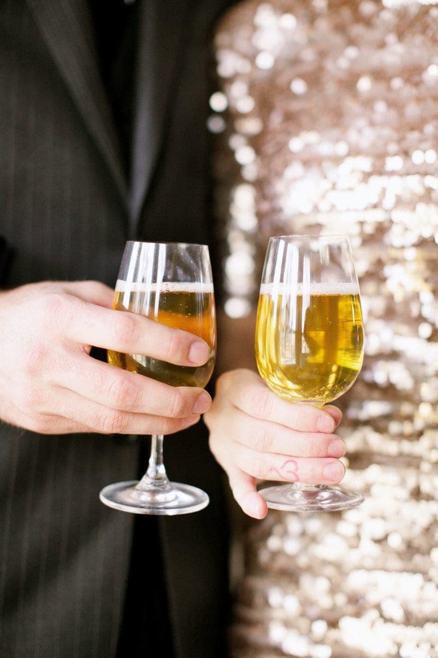 A couple holding glasses of champagne for an easy at home new year's eve party.