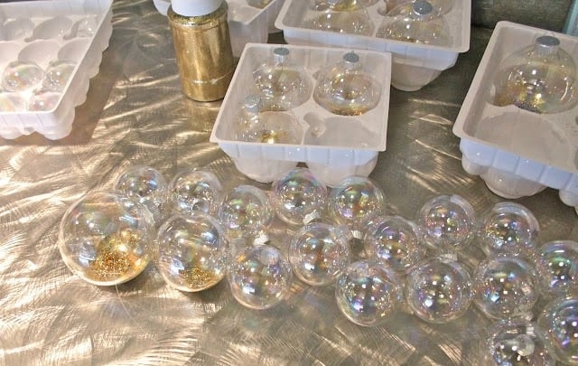 Ornament balls being strung on fishing line to create the garland