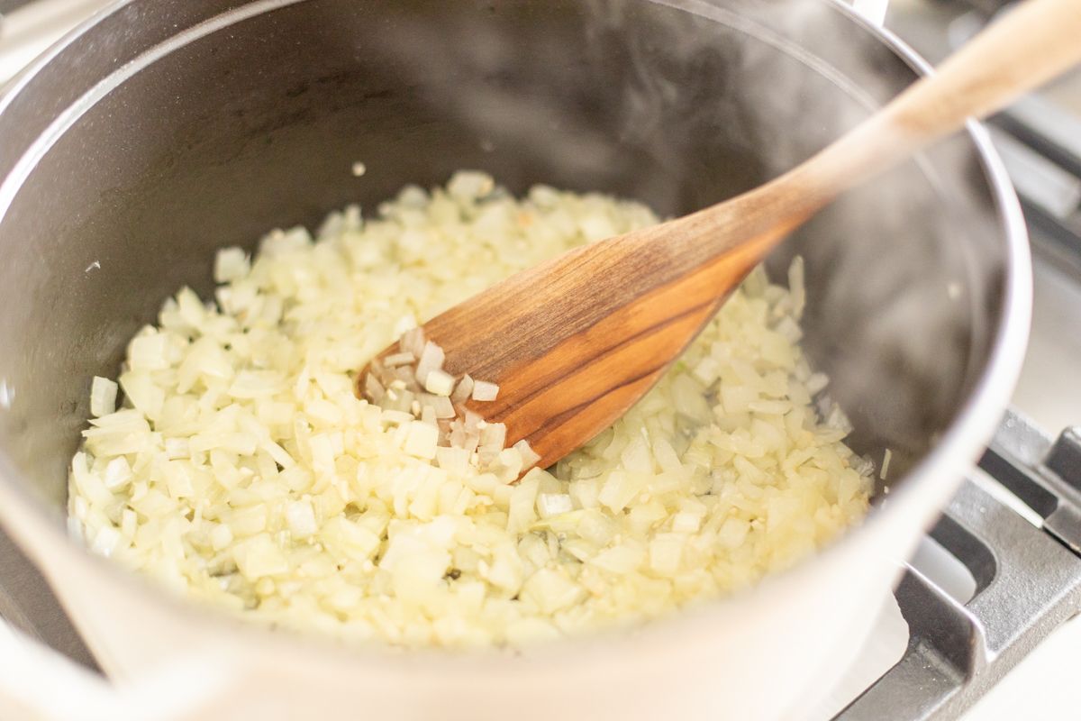 chopped onions cooking in a cast iron pot.