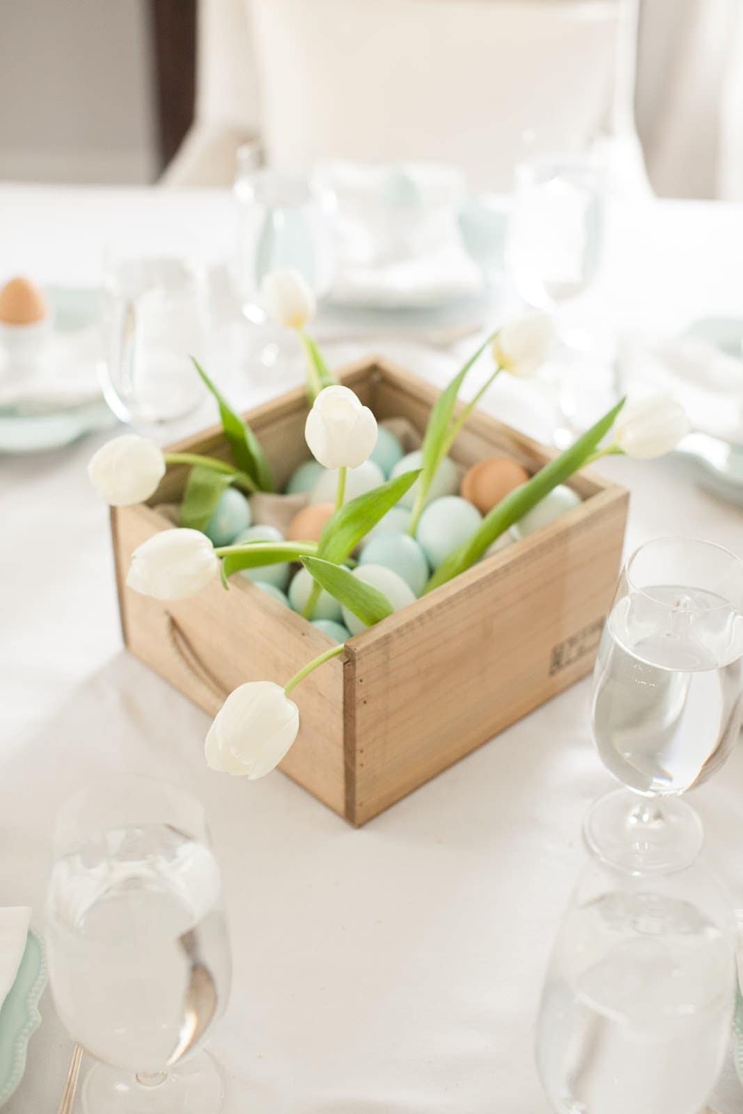 A wooden box filled with easter eggs in the center of Easter table decor