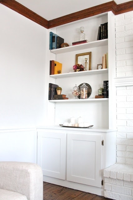 Shelves with knick knacks on them over a book case.